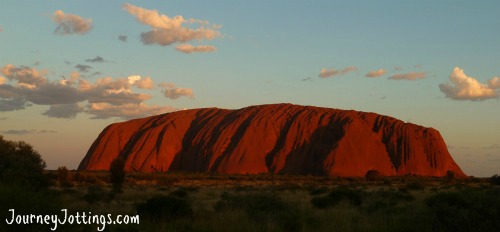 A distant photo of Uluru at sunset taken from across the plains